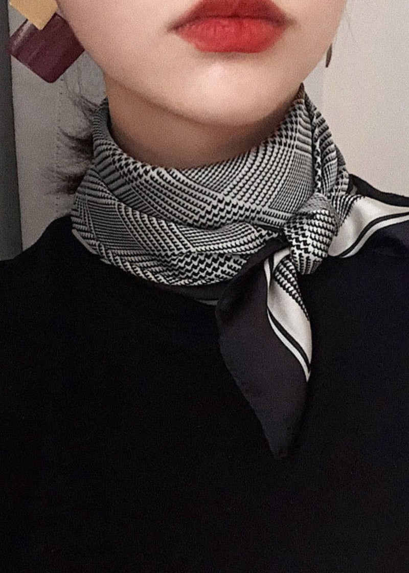 Person wearing a black and white patterned scarf with red lipstick.