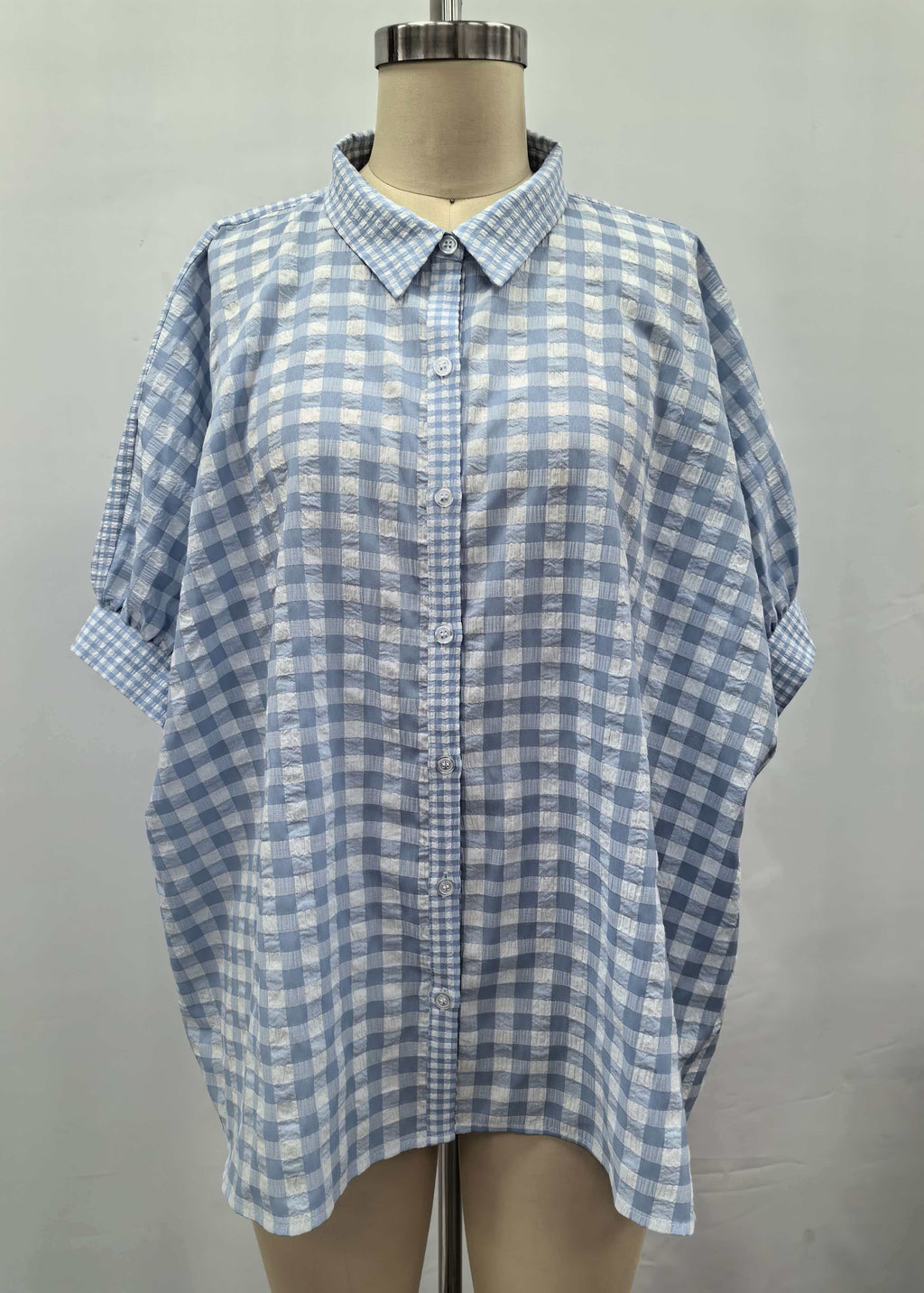 Blue and white checkered shirt on a mannequin against a plain background