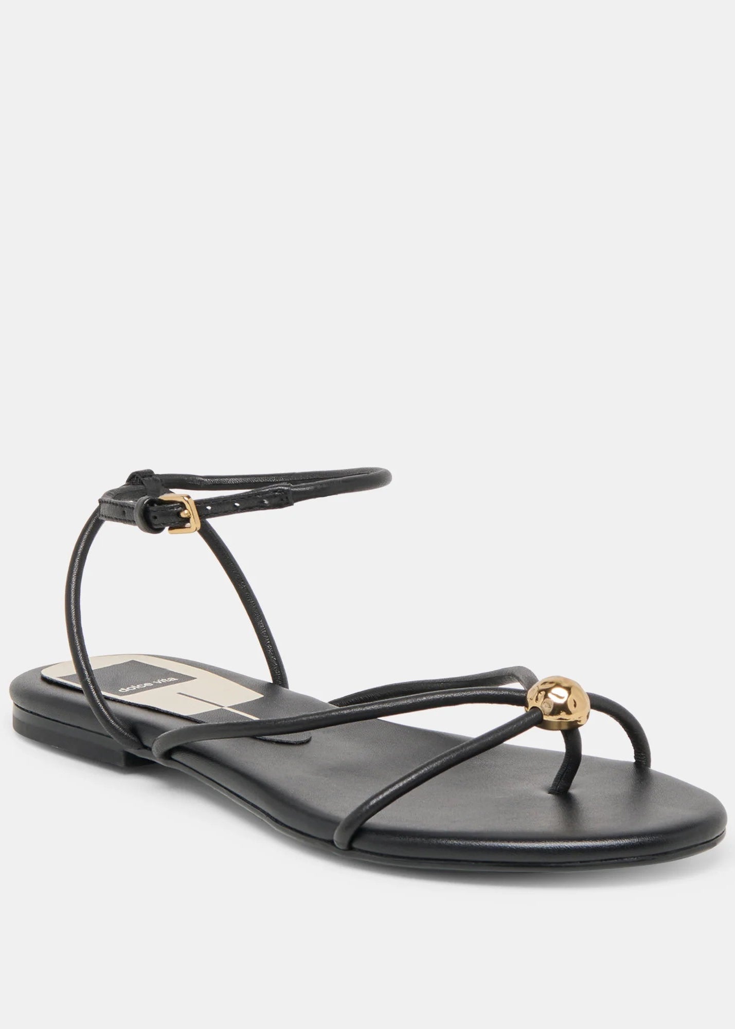 Black sandal with thin straps and gold accents on a white background