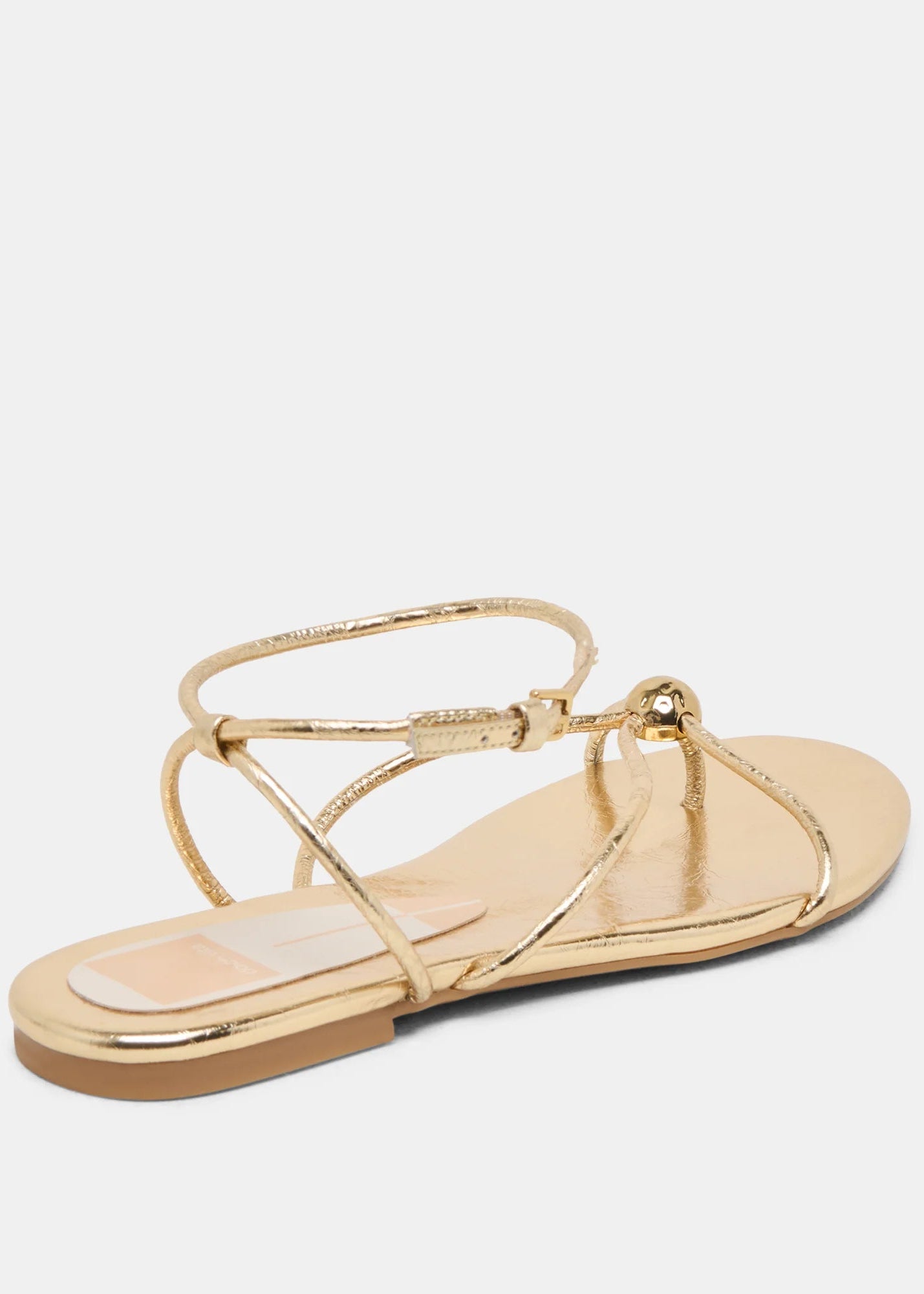 Gold sandal with thin straps on a white background