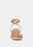 Tan sandal with thin straps on a white background