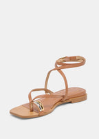 Tan sandal with a thin strap on a light gray background