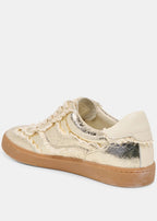 Beige sneaker with gold accents on a white background