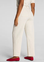 Person wearing white pants and red shoes on a plain background