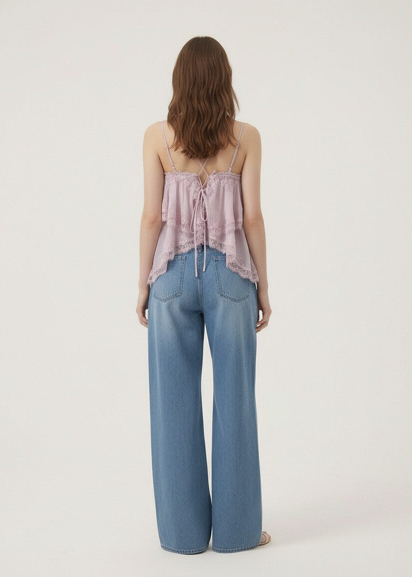 Woman wearing a pink top and blue jeans on a white background