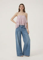Woman wearing a pink strapless top and blue jeans on a white background