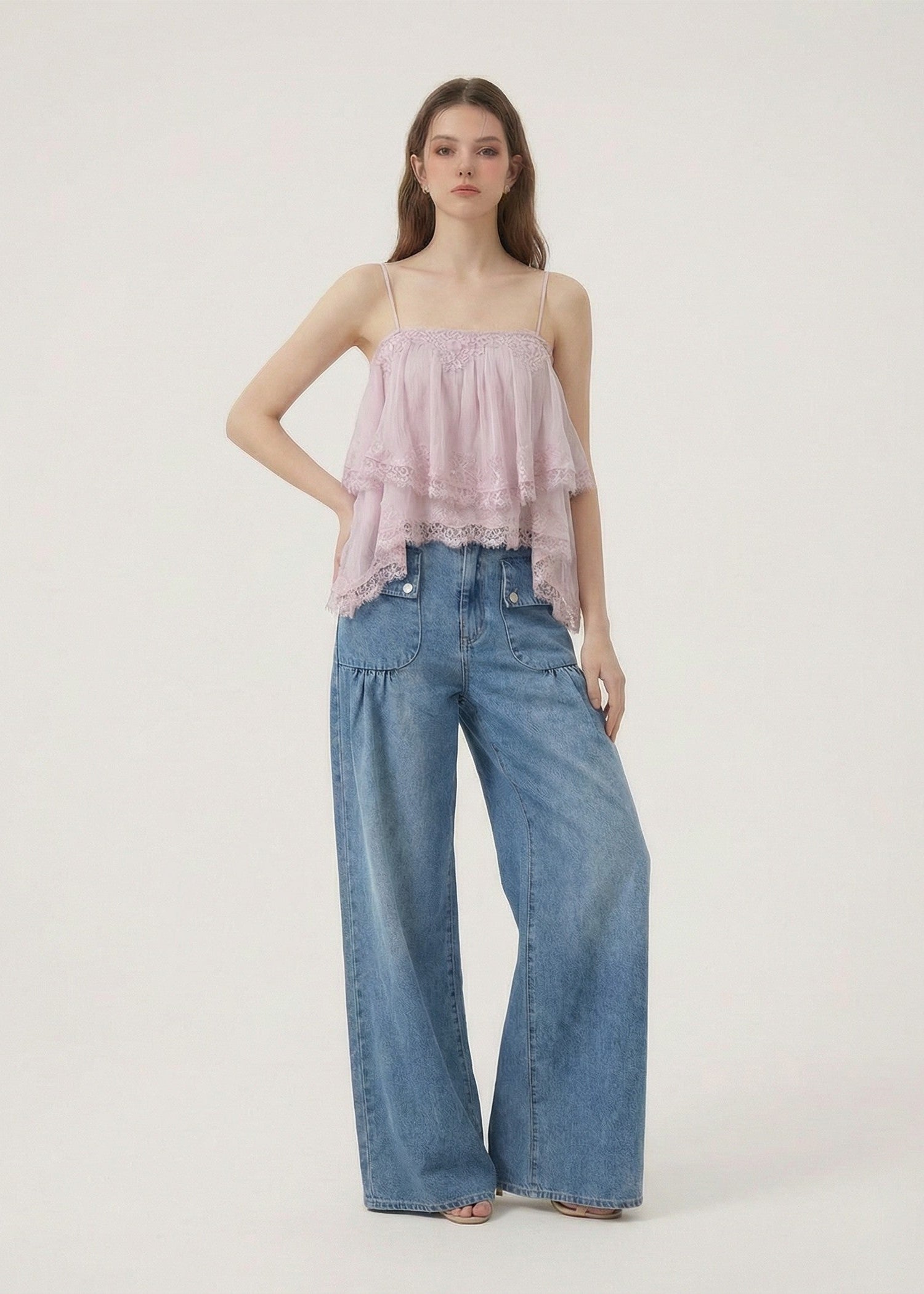 Woman wearing a pink strapless top and blue jeans on a white background