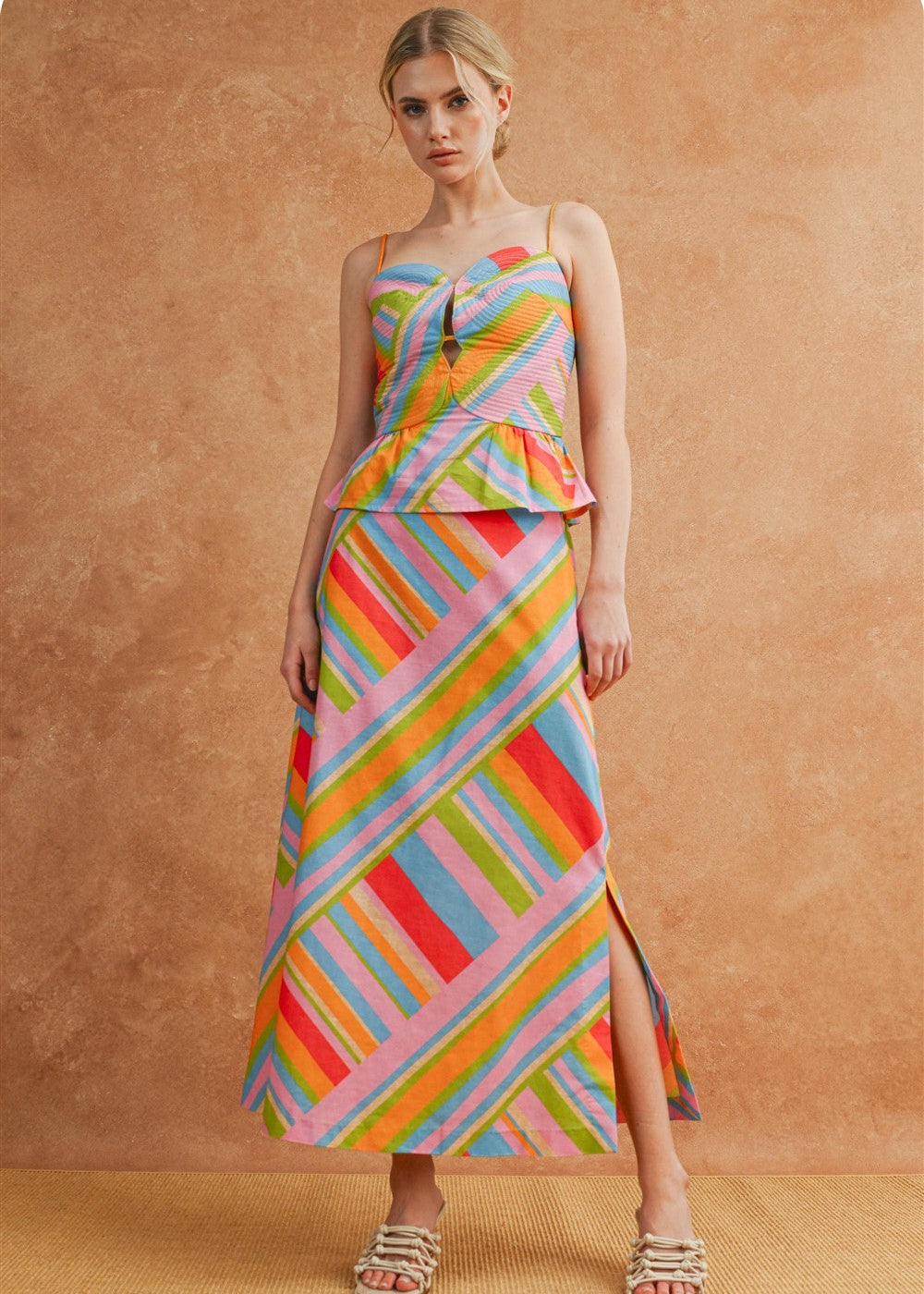 Woman wearing a colorful striped dress against a brown background