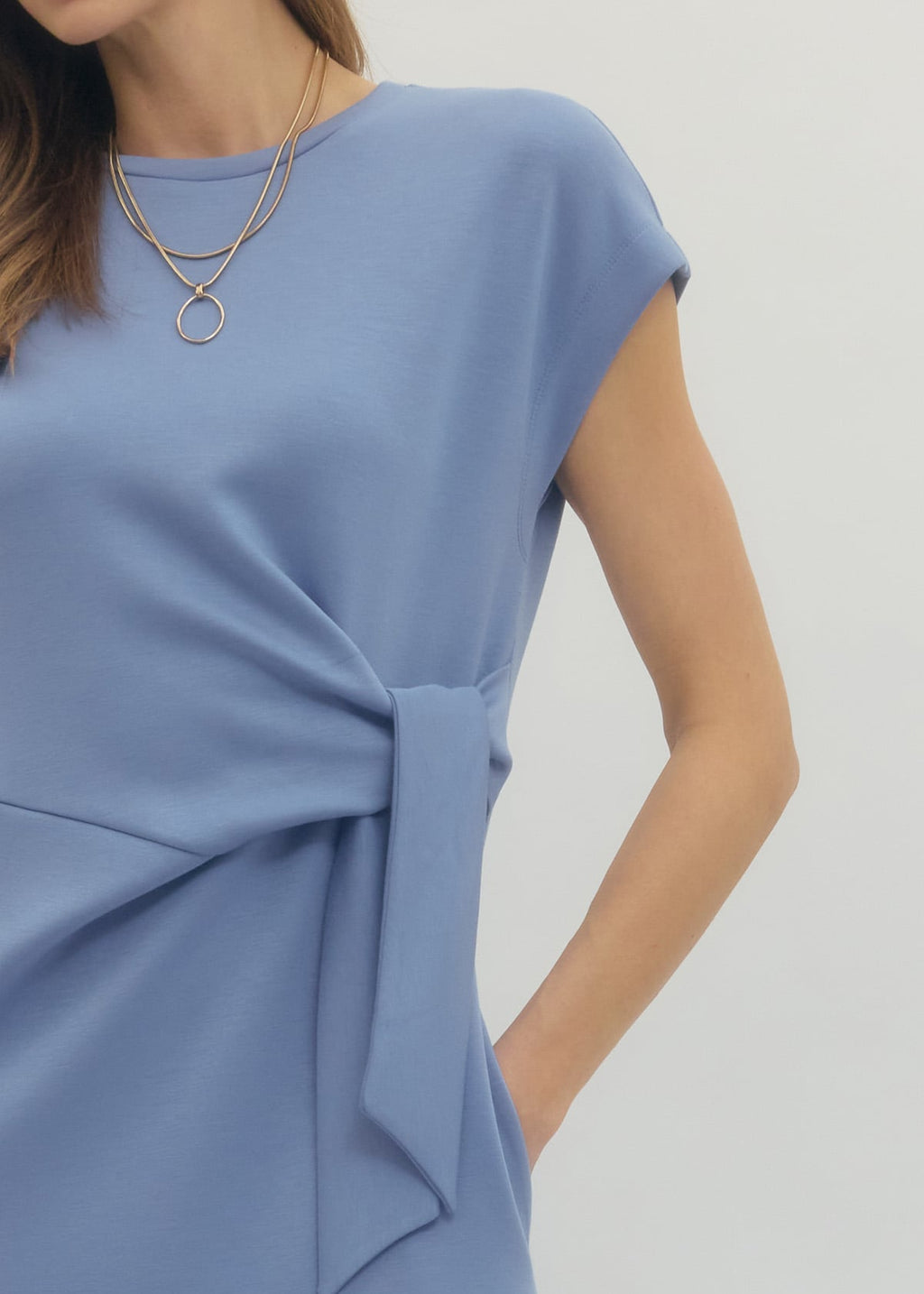Blue dress with a knot detail on a plain background