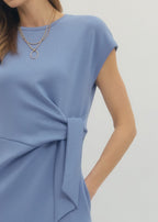 Blue dress with a knot detail on a plain background