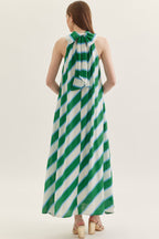 Woman wearing a green and white striped dress on a plain background