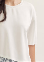 White blouse worn by a person on a plain background