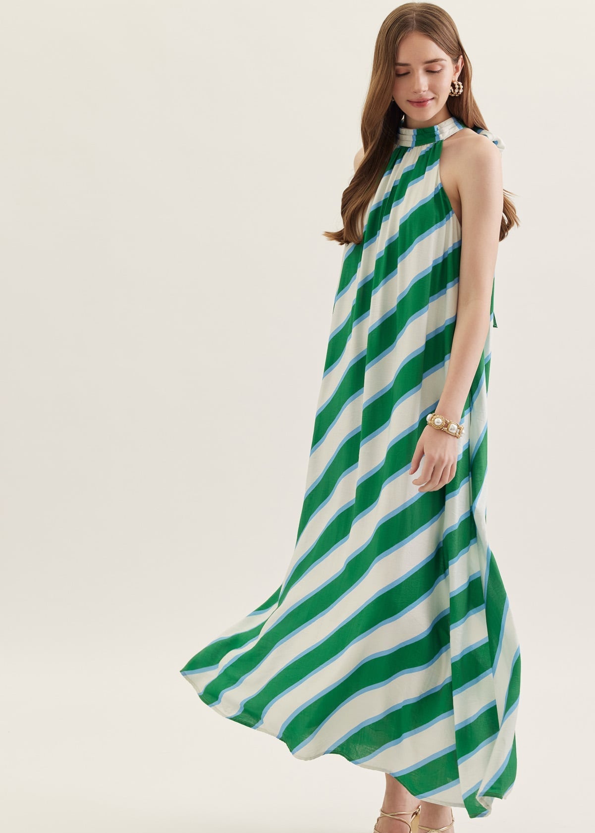 Woman wearing a green and white striped dress on a white background
