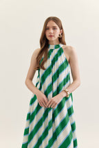 Woman wearing a green and white striped dress on a plain background
