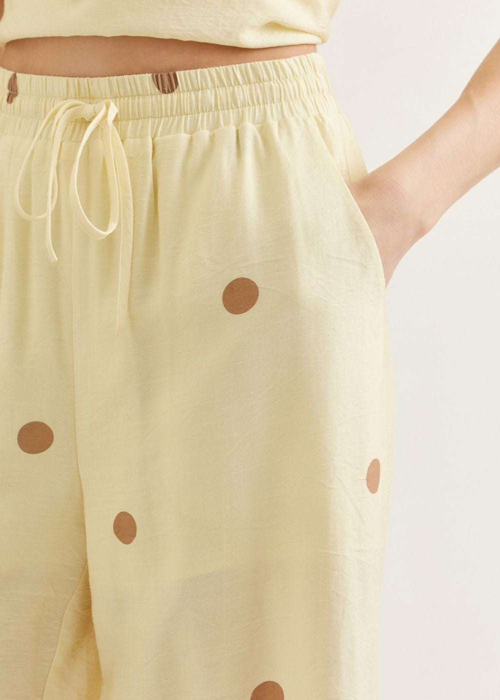 Yellow pants with brown polka dots on a white background